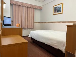 新泻Hotel Alpha-One Niigata的酒店客房配有一张床和一张带电脑的书桌