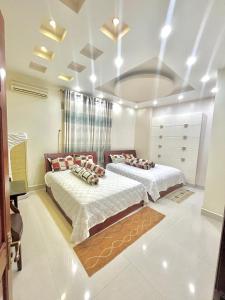 朱笃Cherry Homestay - Hoàng Đế motel的白色墙壁客房的两张床