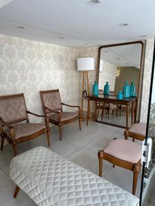 尤西德福拉Apartamento no centro de Juiz de Fora的配有椅子、镜子和桌子的房间