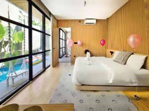 KemiriAkaya Villas Solo的卧室配有一张床,墙上装有气球