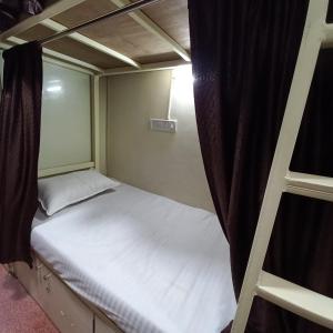 孟买New Assar International dormitory的小卧室设有一张床和梯子