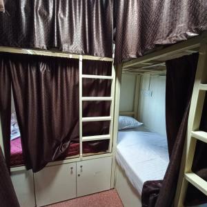 孟买New Assar International dormitory的宿舍间设有两张双层床和梯子。