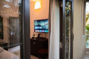 果阿旧城La Ritz beach luxury hotel的客房设有电视、桌子和窗户。
