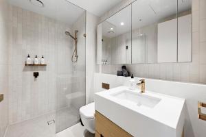 墨尔本Luxuria Apartments - Collins House的白色的浴室设有水槽和卫生间。