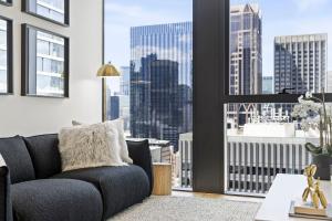 墨尔本Luxuria Apartments - Collins House的带沙发和大窗户的客厅
