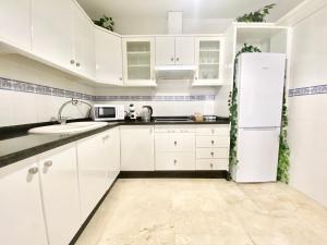 安特克拉Apartamento Andalucía Centro III的厨房配有白色橱柜和冰箱。