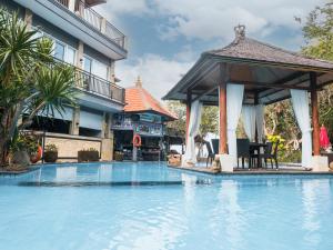 甘地达萨湾畔简易别墅酒店的一座游泳池,毗邻一座建筑,设有凉亭