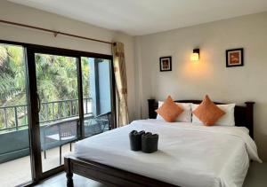 蔻立Srichada Hotel Khaolak - SHA Extra Plus的一间卧室设有一张床和一个阳台