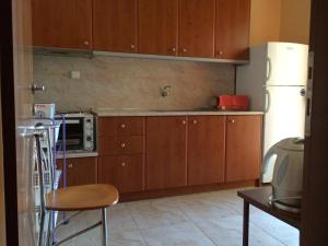 基拉奇尼Kostas House的厨房配有木制橱柜和白色冰箱。