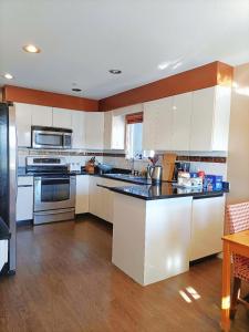 温哥华LLT HomeAway的厨房配有白色橱柜和黑色台面