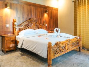 甘地达萨海柏别墅酒店的一间卧室配有一张大床,上面有天鹅
