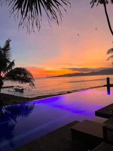 甘地达萨海柏别墅酒店的海洋上的日落,带游泳池