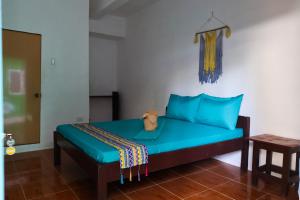 圣维森特Garpeza Backpackers的一间卧室配有一张蓝色的床,猫坐在床上