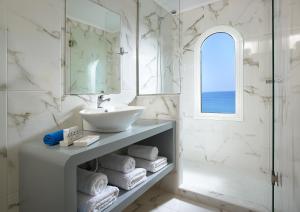 依拉佩特拉Coral Hotel的白色的浴室设有水槽和镜子