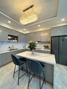 胡志明市Amazing Merit Ben Thanh的厨房配有桌椅和花瓶