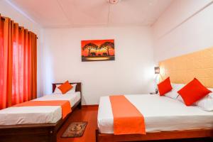 科伦坡Regent Residencies - Colombo的一间卧室配有两张带橙色和白色床单的床