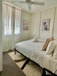 肯图巴Katoomba Hideaway - Blue Mountains Modern Getaway的白色的卧室设有床和窗户