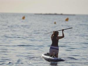 昂蒂布雅博特精品酒店的水中一个在桨板上的女人