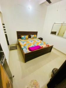范兰德凡Nirupam Sadan HomeStay的一间卧室配有一张大床,提供色彩缤纷的床单和枕头