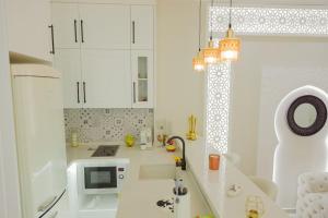 马赫迪耶Maison SOUAD的白色的厨房配有水槽和微波炉