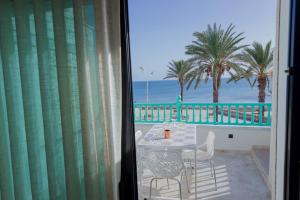 马赫迪耶Maison SOUAD的阳台享有海滩美景,配有桌椅。