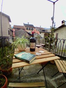 奥尔塔圣朱利奥Casa Longhi的一张木桌,上面放着一瓶葡萄酒和一杯