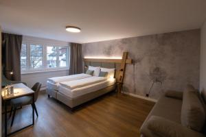 施泰因Hotel Adler的一间卧室配有一张床、一张沙发和一张桌子