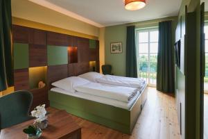 Barweiler阿格内深霍夫酒店的一间卧室配有一张大床和一张桌子