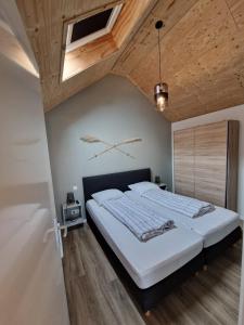 佐特兰德Zoetenaar Zoutelande的一间卧室设有一张带木制天花板的大床
