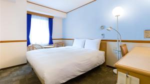 敦贺市Toyoko Inn Tsuruga Ekimae的酒店客房设有白色的床和窗户。