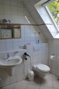 EmsbürenGästehaus am Aa Tal的一间带水槽和卫生间的浴室以及窗户。