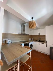 普罗旺斯艾克斯Deux chambres avec terrasse dans le centre ville d'Aix en Provence的厨房配有白色橱柜和木制台面