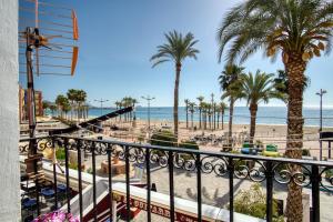 比利亚霍约萨El Desembarco的享有海滩和棕榈树景致的阳台