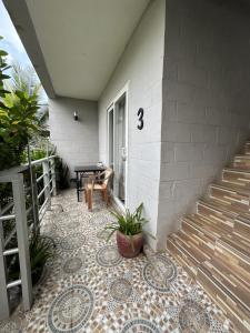 西哈努克Ginger Sihanoukville的门廊铺有瓷砖地板,房屋旁设有楼梯