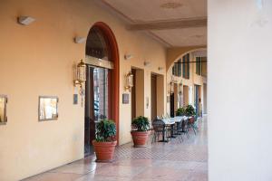 科雷焦Phi Hotel Dei Medaglioni的走廊上设有盆栽和桌椅