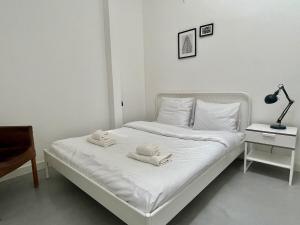 鹿特丹Stylish 2 Bedroom Serviced Apartment in Rotterdam的卧室内的白色床和毛巾
