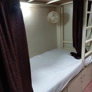 孟买New Assar International dormitory的一间卧室配有带窗帘的双层床