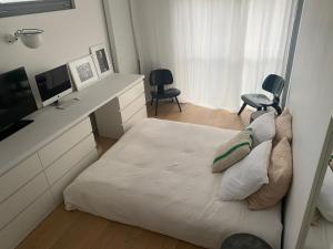 克雷泰伊Maison d'architecte - Piscine的一间卧室配有一张床和一张书桌及电视