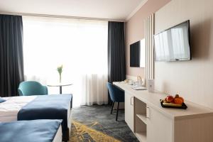 韦切什布达佩斯机场酒店的配有一张床和一张书桌的酒店客房