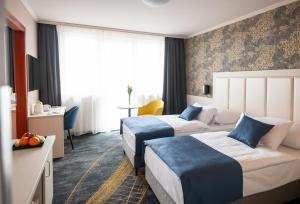 韦切什布达佩斯机场酒店的酒店客房设有两张床和一张桌子。