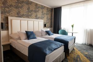 韦切什布达佩斯机场酒店的酒店客房 - 带两张带蓝色枕头的床