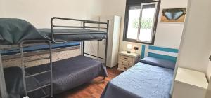 蓬塔翁布里亚Delux Center Punta Umbría的小房间设有两张双层床和一张床