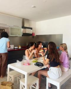 卡米尼亚Arca Nova Guest House & Hostel Caminha的一群坐在厨房桌子旁的女人