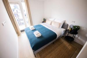 鹿特丹Grandly 3 Bedroom Serviced Apartment 83m2 -NB306G-的一间卧室配有一张大床和毛巾