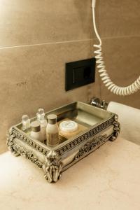 基希讷乌周末精品酒店 的浴室柜台上装有化妆品的银盘
