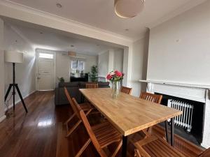 悉尼3 Bedroom House Family Friendly Surry Hills 2 E-Bikes Included的客厅配有木桌和壁炉