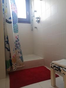 卡尔米尼亚诺Residence S.Cristina的浴室配有浴缸、淋浴和红色地毯。