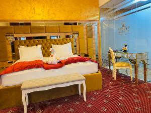 弗格拉什Vila Imperial One Luxury Boutique Hotel的一间卧室配有一张带书桌和一张桌子的床。