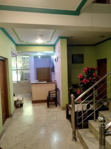 斯利那加Hotel Foothills , Srinagar的一间绿色墙壁和鲜花桌的房间