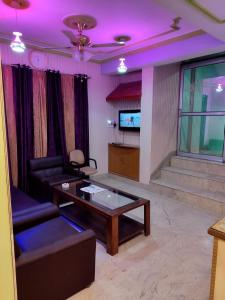 斯利那加Hotel Foothills , Srinagar的带沙发、桌子和电视的客厅